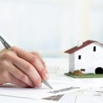 Extreme close up of female hand signing real estate contract.